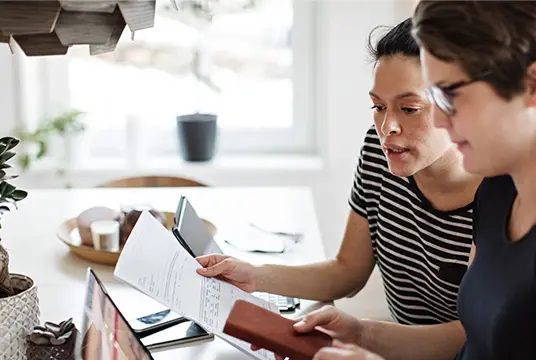 Två kvinnor tittar på ett papper