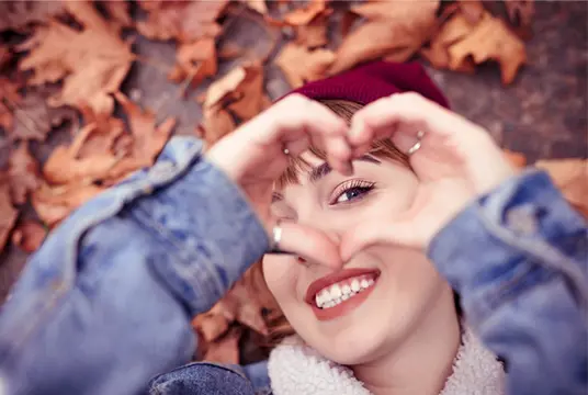 Tjej gör hjärta med händerna