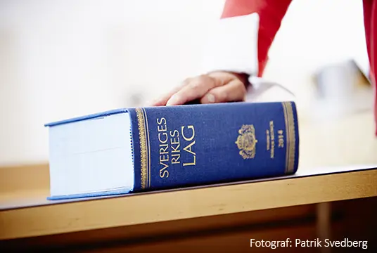 Hand på lagbok. Fotograf Patrik Svedberg