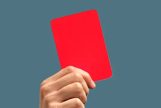 En hand håller upp ett rött kort